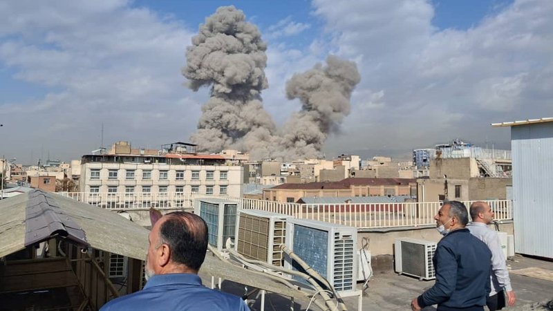 Menschen beobachten Rauch nach einer Explosion in Teheran. | Bild: Uncredited/AP/dpa Menschen beobachten Rauch nach einer Explosion in Teheran.