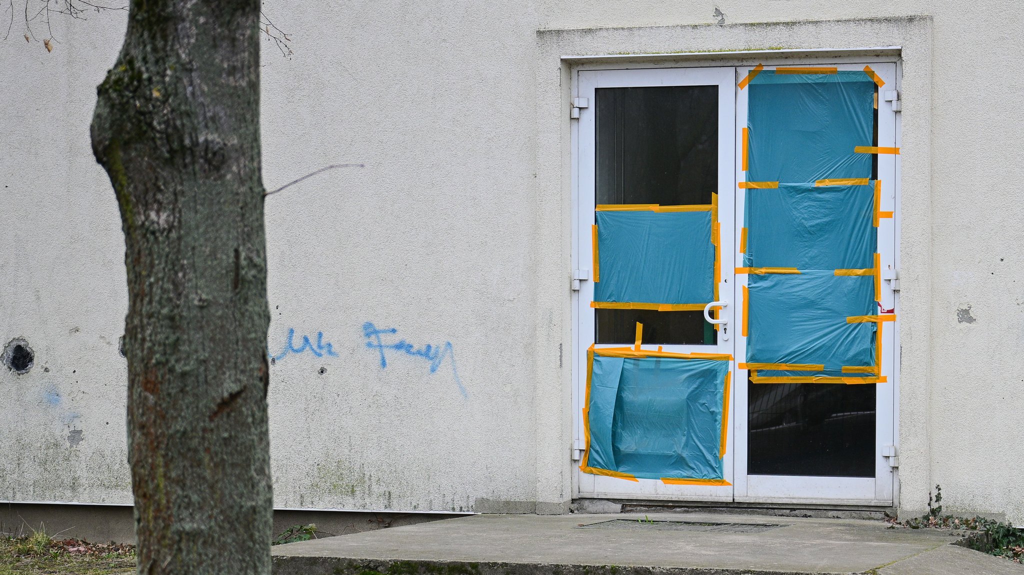 Planen decken an einer Unterkunft für Geflüchtete die beschädigten Scheiben einer Tür ab. Das Übergangswohnheim für Asylsuchende wurde angegriffen. Archivbild vom 11.3.25 | Bild: picture alliance/dpa/Sebastian Christoph Gollnow Planen decken an einer Unterkunft für Geflüchtete die beschädigten Scheiben einer Tür ab. Das Übergangswohnheim für Asylsuchende wurde angegriffen. Archivbild vom 11.3.25