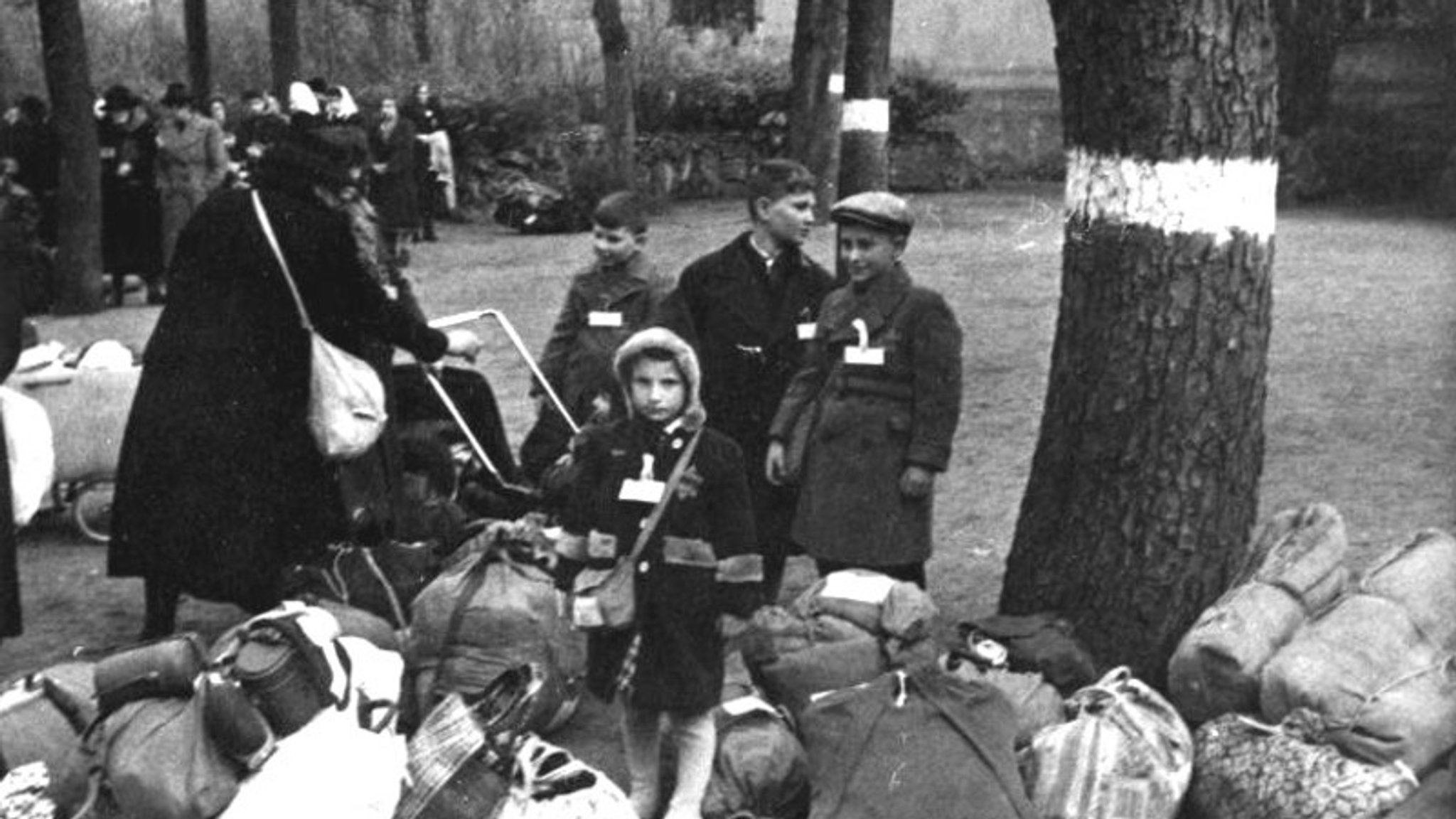 Eine Familie wartet an der Sammelstelle, heute Ecke Friedrich-Ebert-Ring/St.-Benedikt-Straße, auf die Deportation.