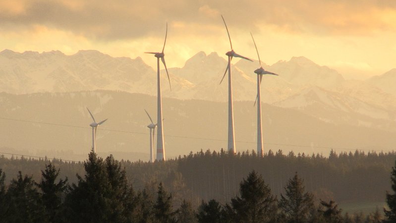 Windräder im Allgäu vor Bergkulisse