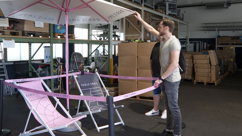 Sportgeschichte wird versteigert - darunter Sonnenschirme und Stühle, die bei den Olympischen Spielen in Paris im Einsatz waren. | Bild: BR Sportgeschichte wird versteigert - darunter Sonnenschirme und Stühle, die bei den Olympischen Spielen in Paris im Einsatz waren.