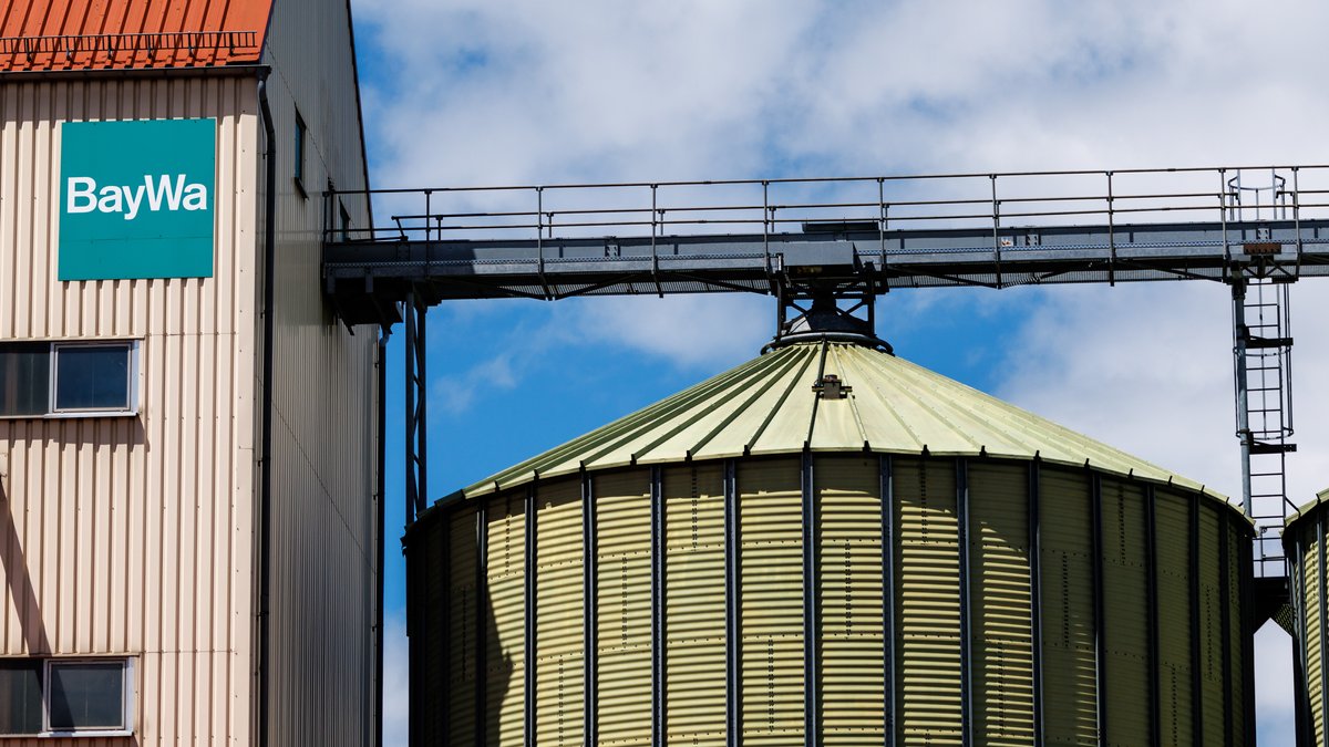 Das Logo der BayWa an der Fassade von einem Gebäude mit zwei angrenzenden Silos im bayerischen Rehau.