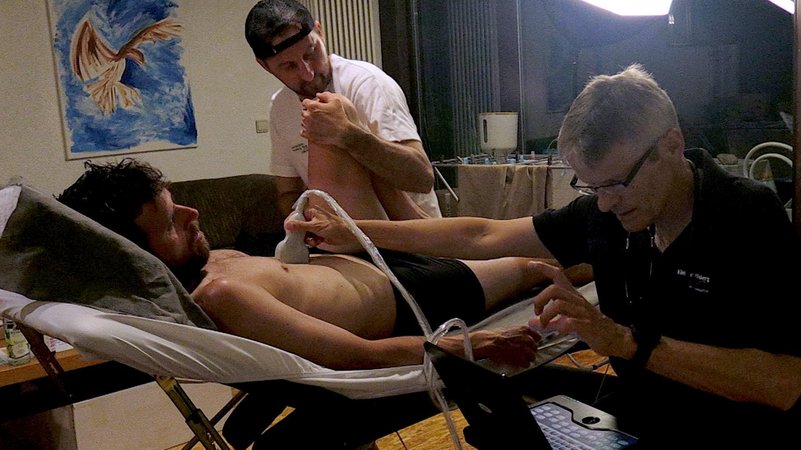 Sportmediziner Bernd Langenstein und Physiotherapeut Andre Hablawetz kümmern sich um Jonas Deichmanns Gesundheit.