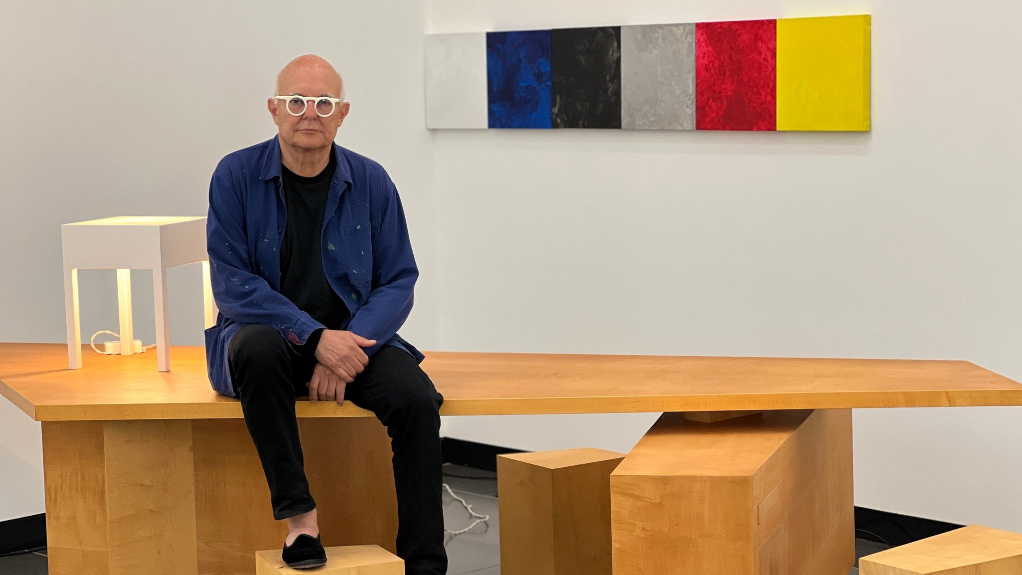 Der Künstler Rolf Sachs sitzt auf einem seiner Designobjekte - einem Schreibtisch