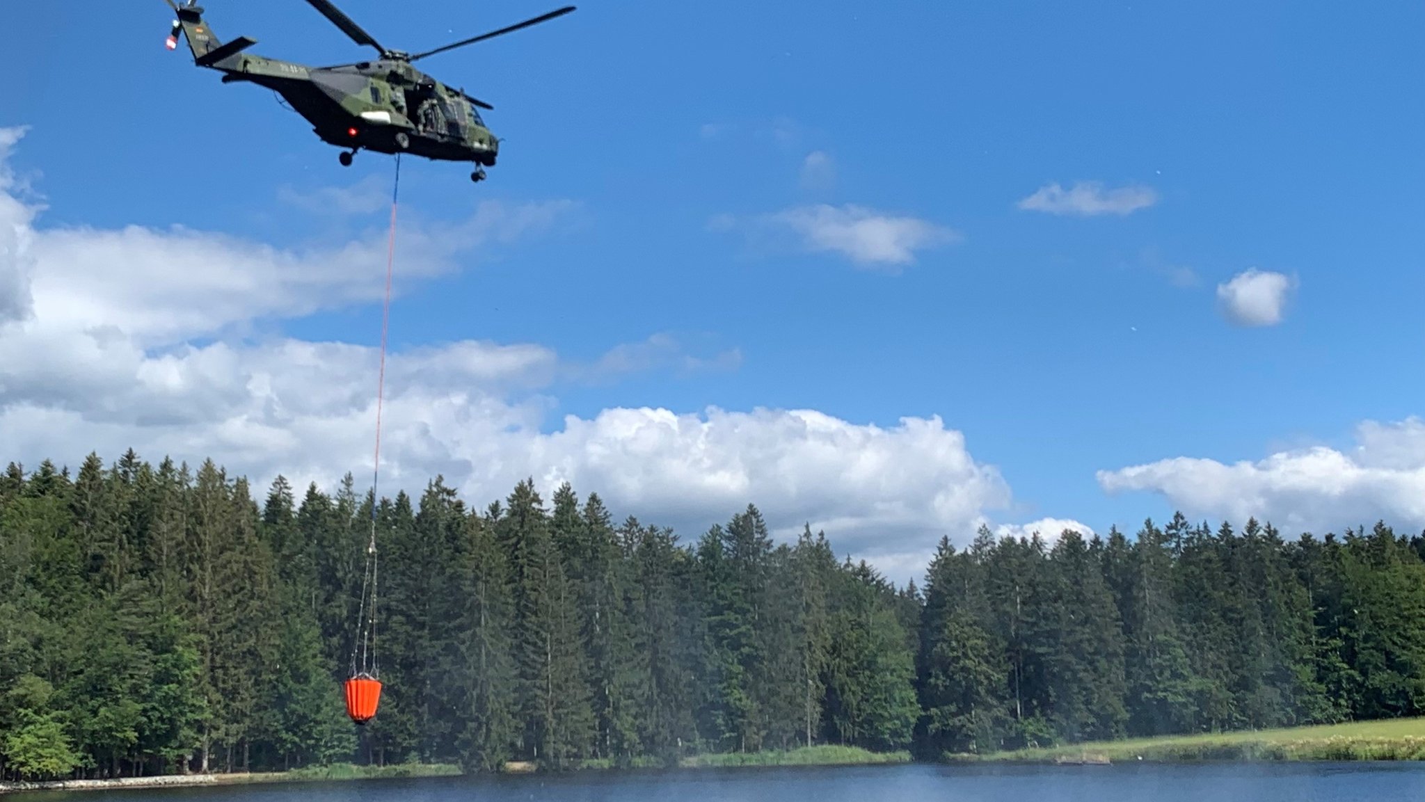 Ein Bundeswehrhubschrauber bei der Wasseraufnahme aus dem Stausee Großarmschlag