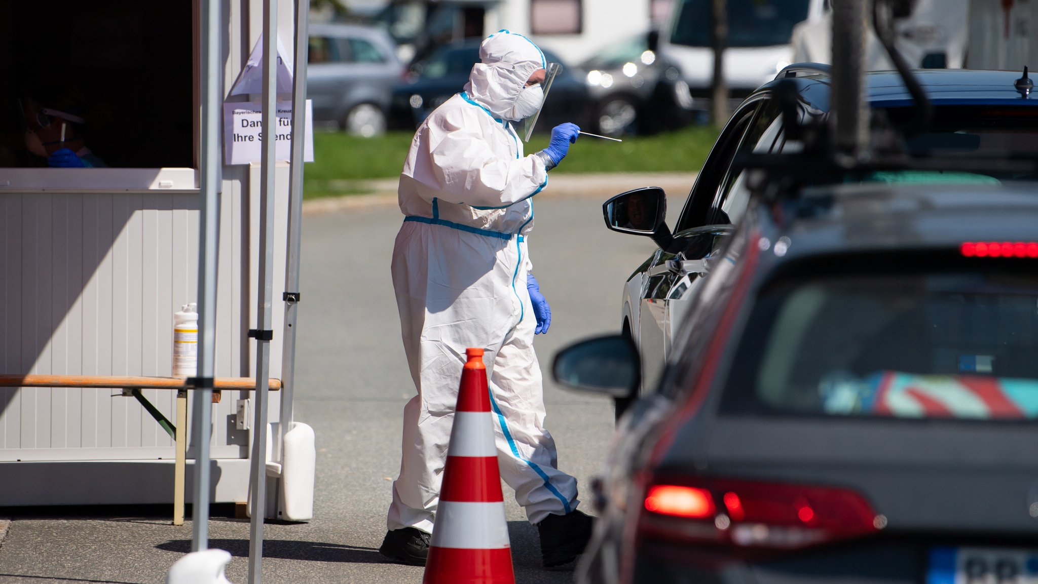 Ein Mitarbeiter vom Bayerischen Roten Kreuz nimmt an einem Corona-Testzentrum an der Autobahn 8 (A8).