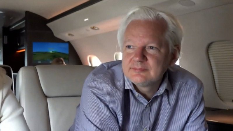 Julian Assange sitzt in einem Flugzeug