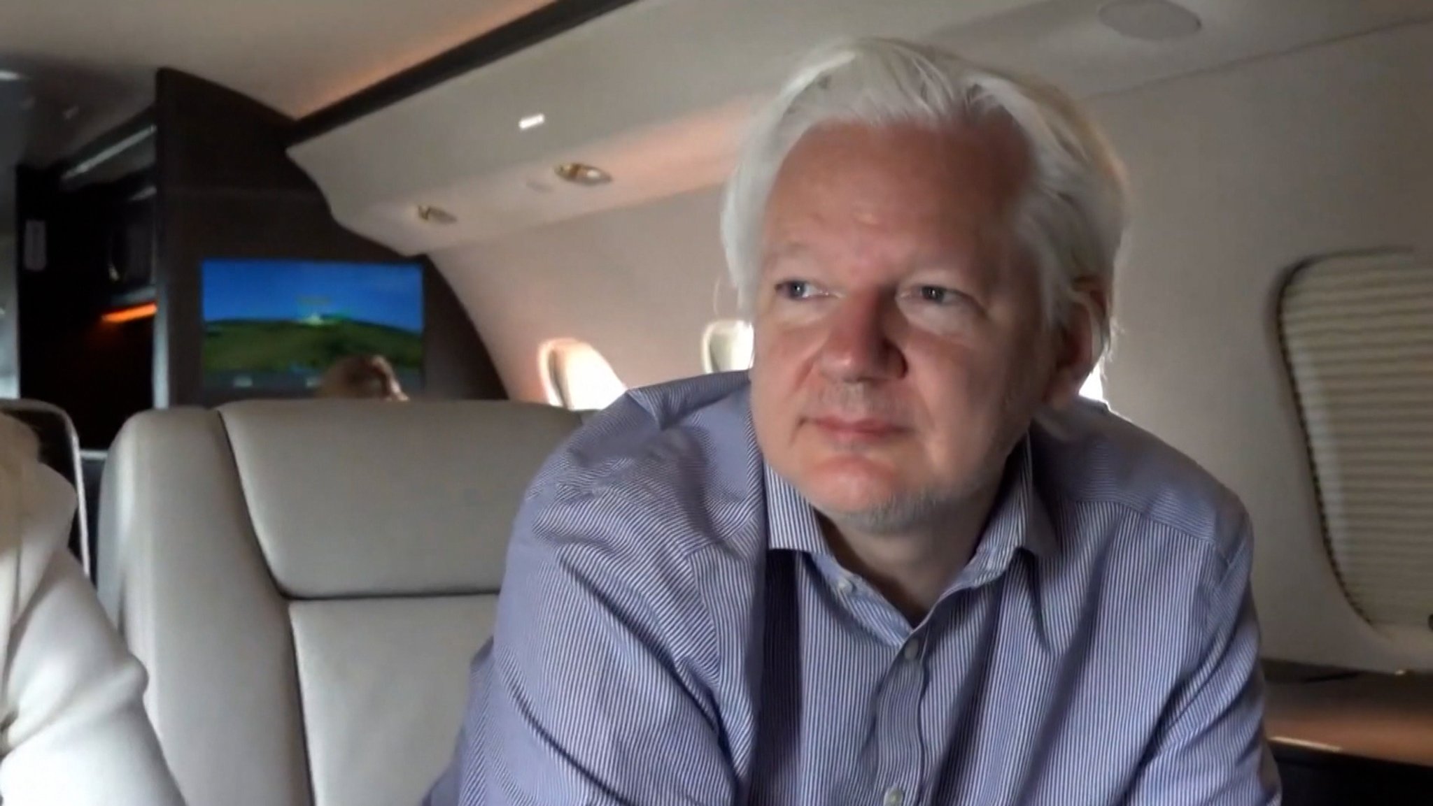 Julian Assange sitzt in einem Flugzeug