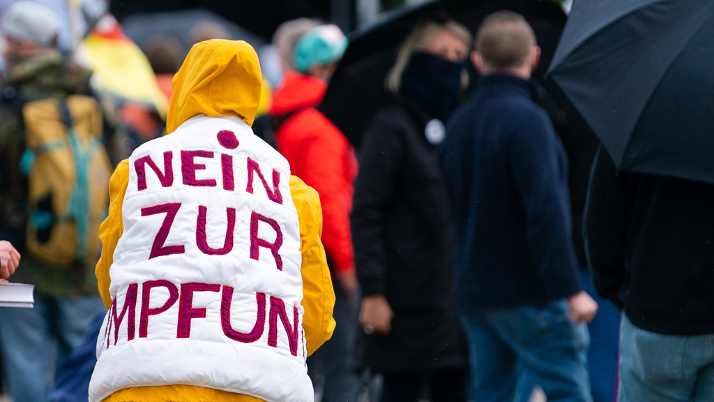 Eine Demonstrantin auf einer Querdenken-Demonstration in Nürnberg trägt eine Jacke mit der Aufschrift "Nein zur Impfung"