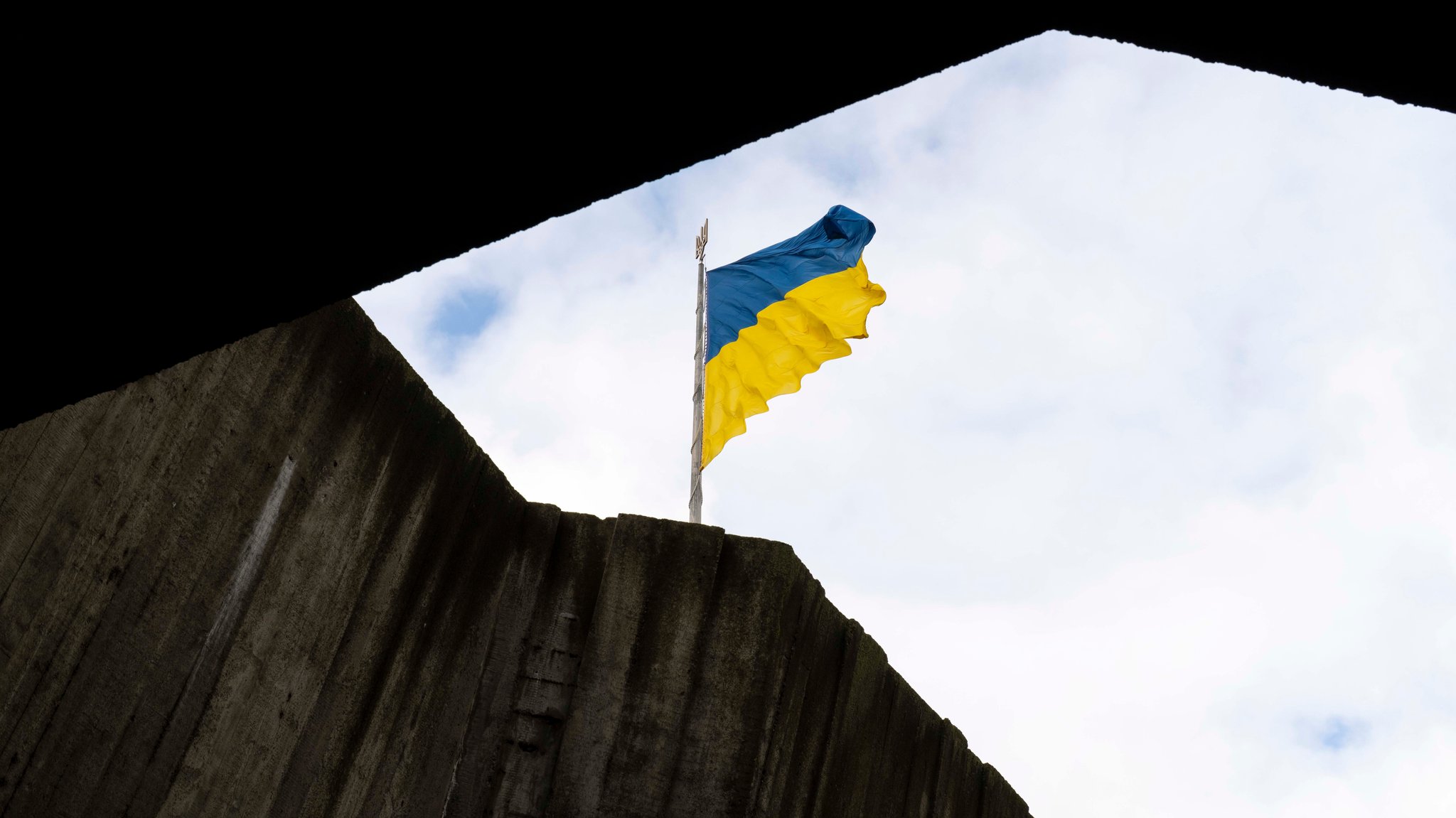 Symbolbild: Ukrainische Flagge weht über einem zerstörten Gebäude | Bild: picture alliance / ZUMAPRESS.com | Andreas Stroh Symbolbild: Ukrainische Flagge weht über einem zerstörten Gebäude