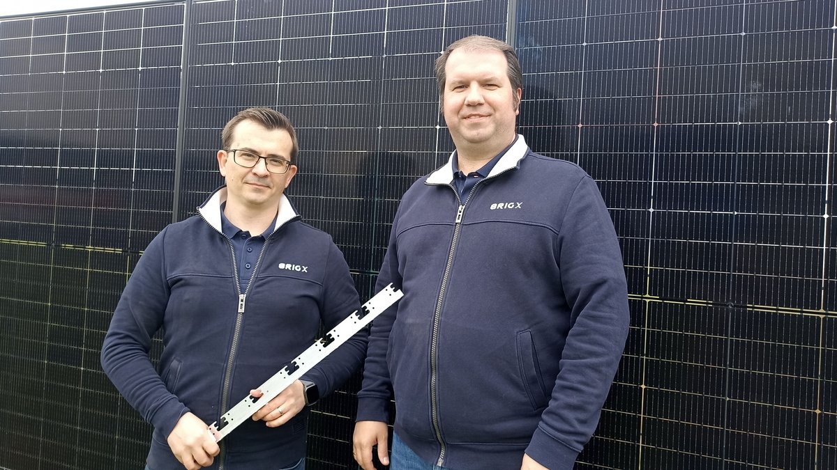 Die Ingenieure Eugen Borgardt (links) und Johann Reis (rechts) mit dem Winkel, mit dem sich Solar-Module an Zäunen aufhängen lassen.