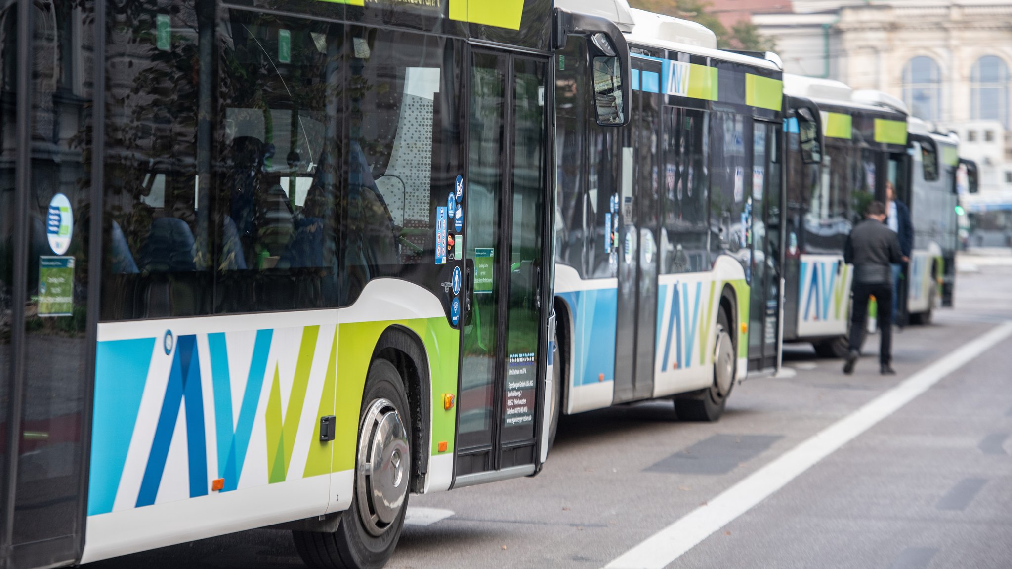 Busse in den Farben des Augsburger Verkehrsverbunds (AVV) stehen in der Fuggerstraße (Symbolbild)