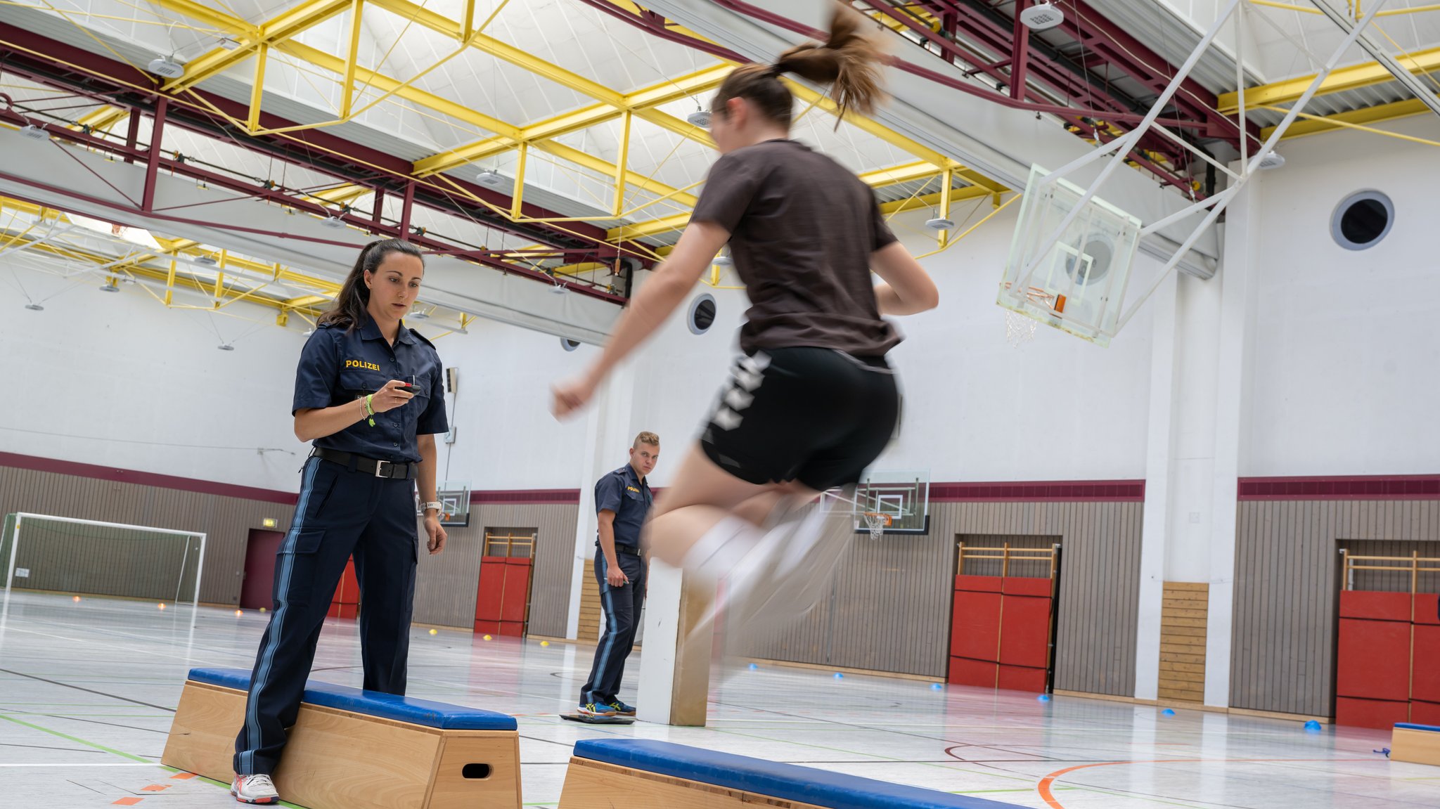 ARCHIV (12.06.2023): Kandidaten für den Mittleren Dienst bei der Bayerischen Polizei nehmen am Sporttest im Rahmen eines zweitägigen Auswahlverfahrens teil. Springen, Sprinten, Bankdrücken - wer zur Polizei will, muss körperlich fit sein.