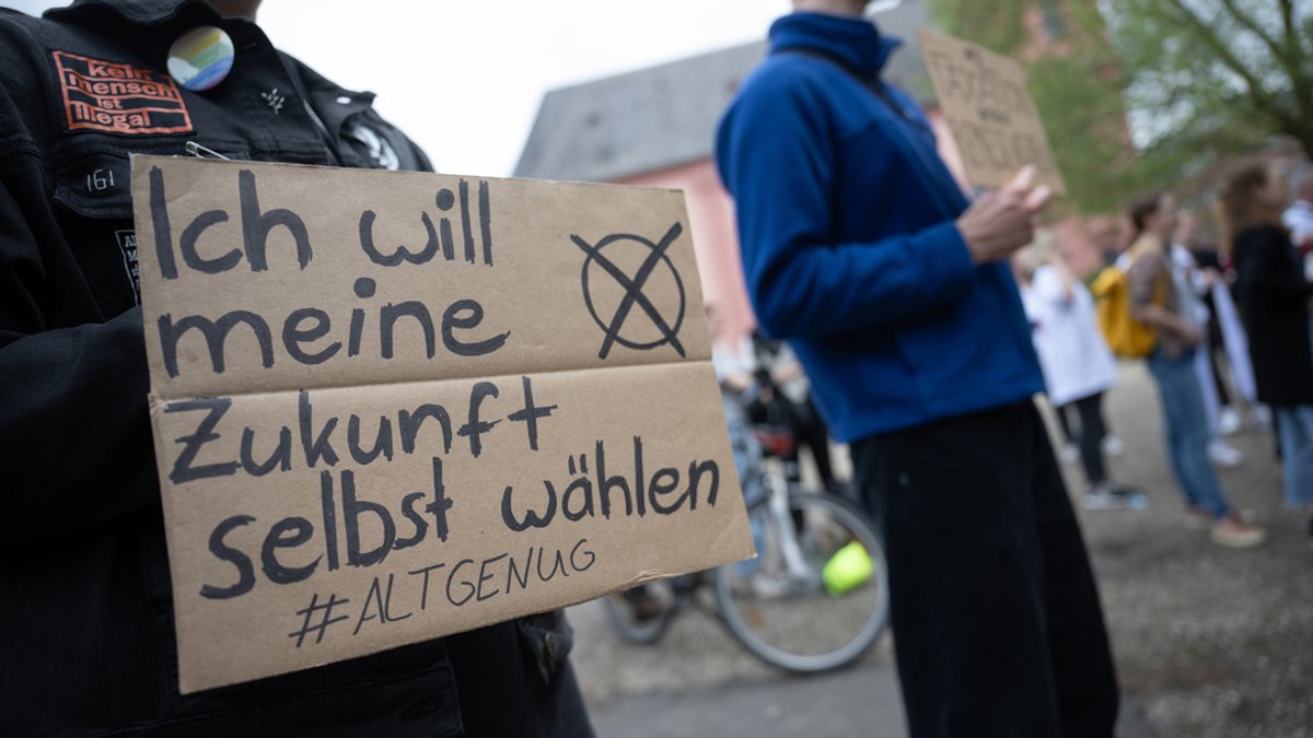 "Ich will meine Zukunft selbst wählen #altgenug" steht auf einem Plakat, das ein Demonstrant bei einer Demo in der Hand hält. 