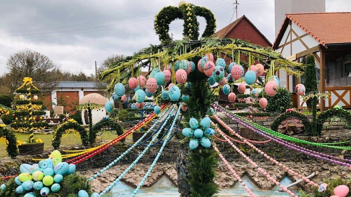 Ein mit bunten Eiern und Ranken geschmückter Osterbrunnen. 