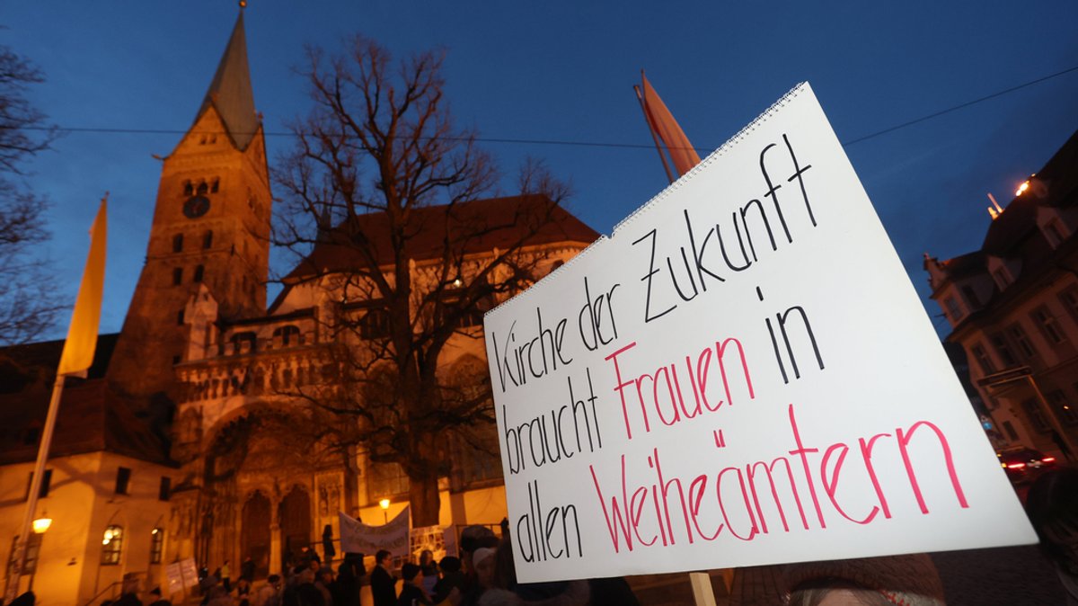 Plakat bei einer Mahnwache vor dem Hohen Dom Augsburg mit der Aufschrift "Kirche der Zukunft braucht Frauen in allen Weiheämtern". (Archivbild)