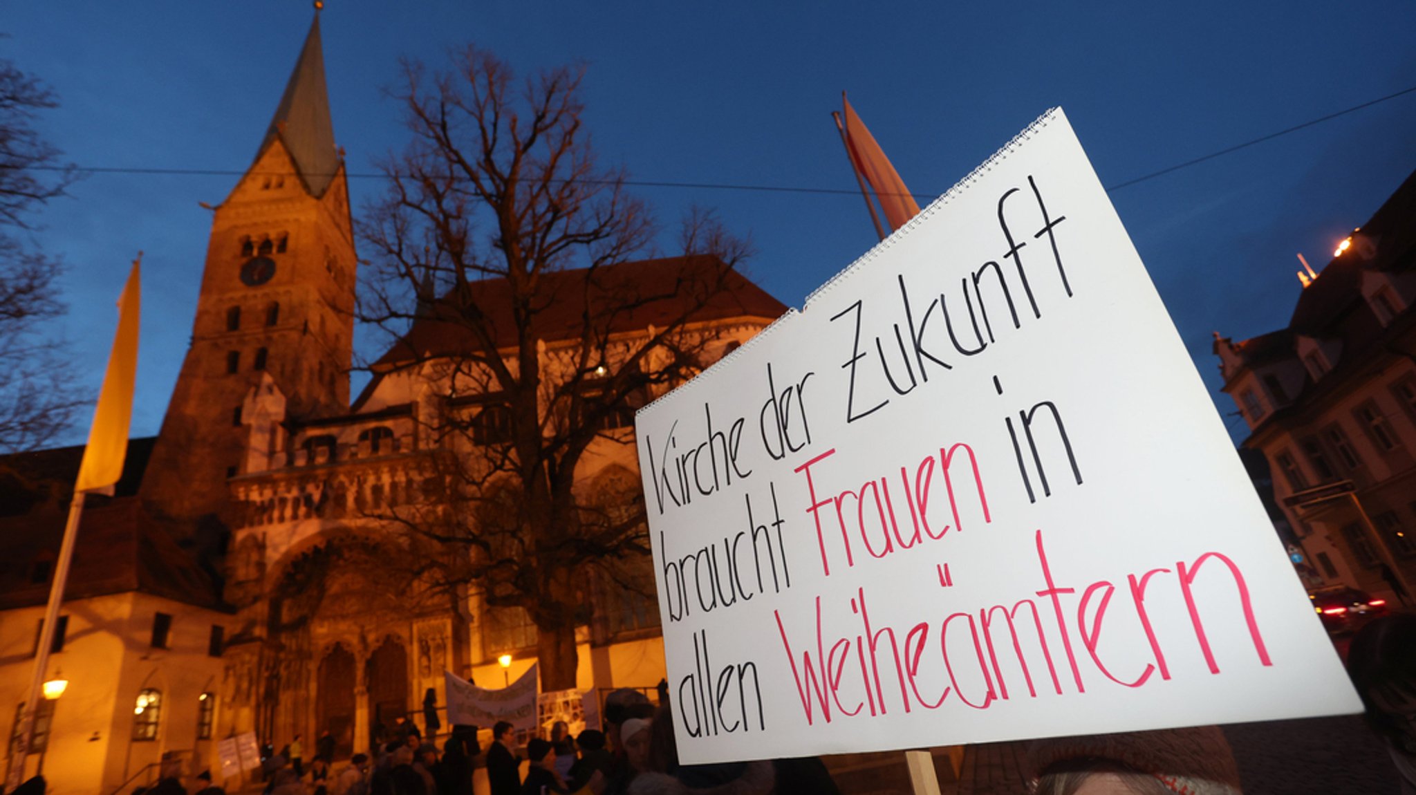 Plakat bei einer Mahnwache vor dem Hohen Dom Augsburg mit der Aufschrift "Kirche der Zukunft braucht Frauen in allen Weiheämtern". (Archivbild)