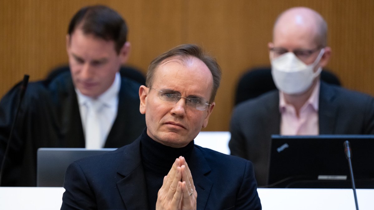 Der frühere Wirecard-Vorstandschef Markus Braun (M) sitzt vor Beginn der Fortsetzung im Wirecard-Prozess auf seinem Platz im Gerichtssaal. Im Hintergrund rechts sitzt der Mitangeklagte im Wirecard-Prozess, Oliver Bellenhaus.