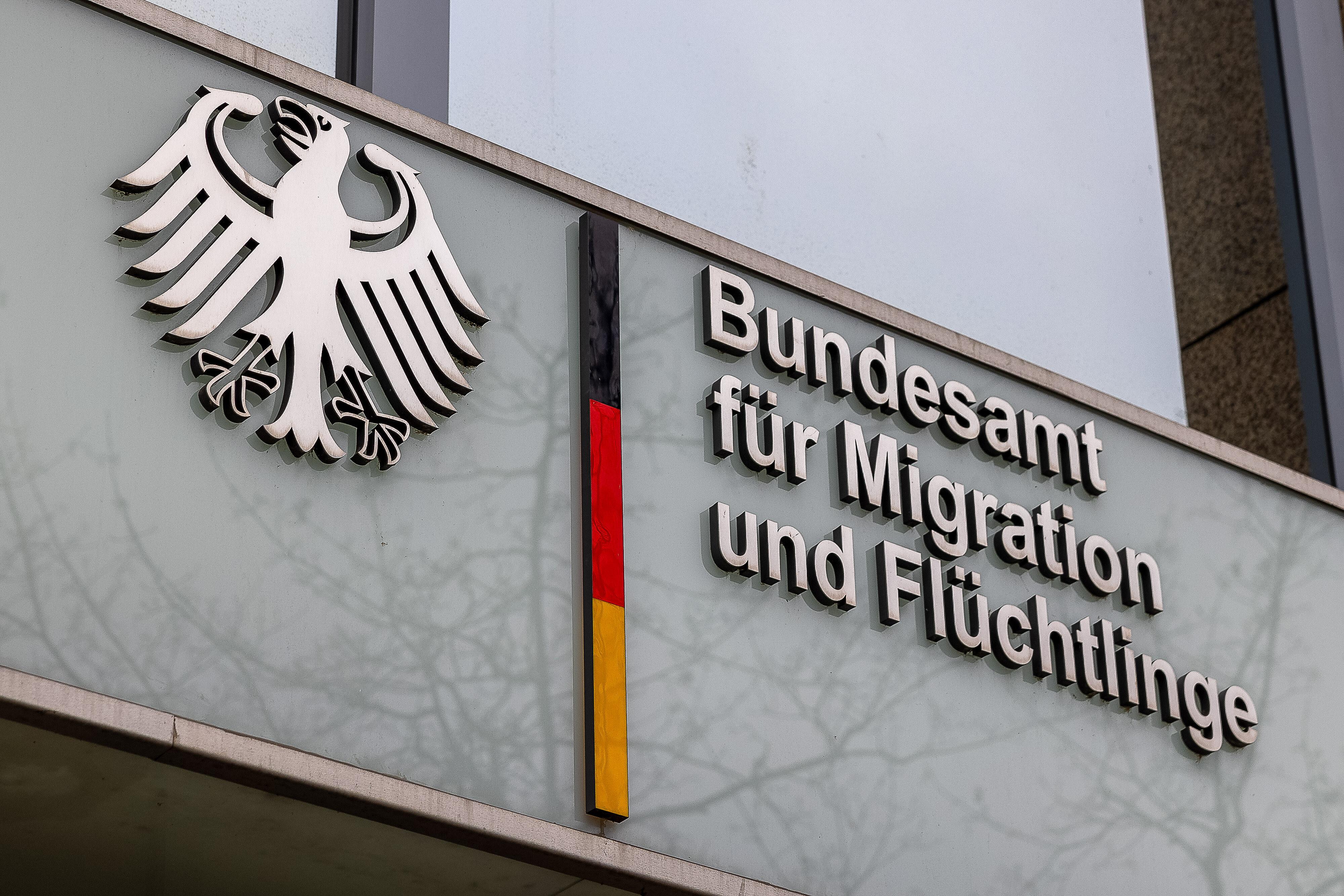 Nahaufnahme des Logos und der Beschriftung des Bundesamts für Migration und Flüchtlinge (BAMF) an der Fassade des Gebäudes.