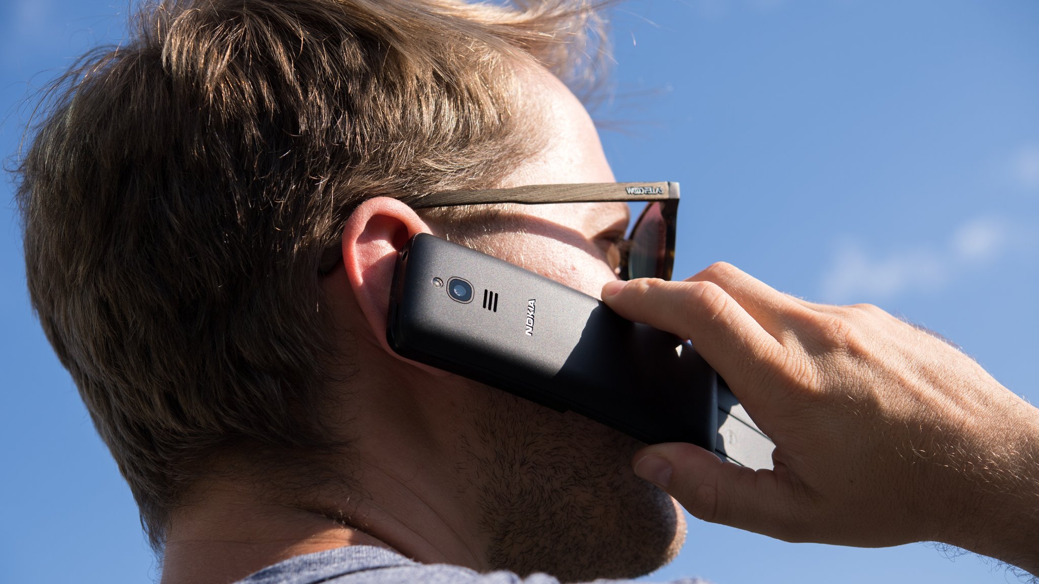 (Symbolbild) Auf dem Bild ist ein Mann zu sehen, der sich ein altes Tasten-Handy an das Ohr hält. Es wirkt so als ob er telefonieren würde. | Bild: picture alliance / dpa Themendienst | Andrea Warnecke (Symbolbild) Auf dem Bild ist ein Mann zu sehen, der sich ein altes Tasten-Handy an das Ohr hält. Es wirkt so als ob er telefonieren würde.