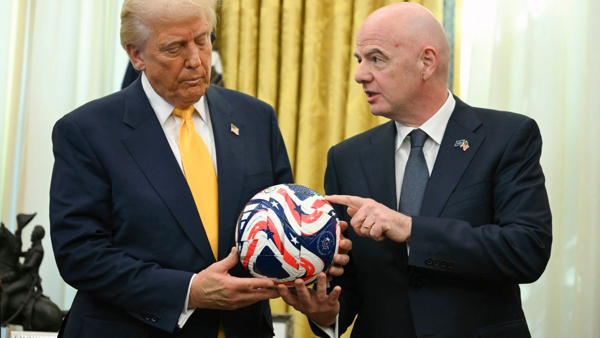 Zu sehen sind US-Präsident Donald Trump und FIFA-Präsident Gianni Infantino, die gemeinsam einen Ball halten.