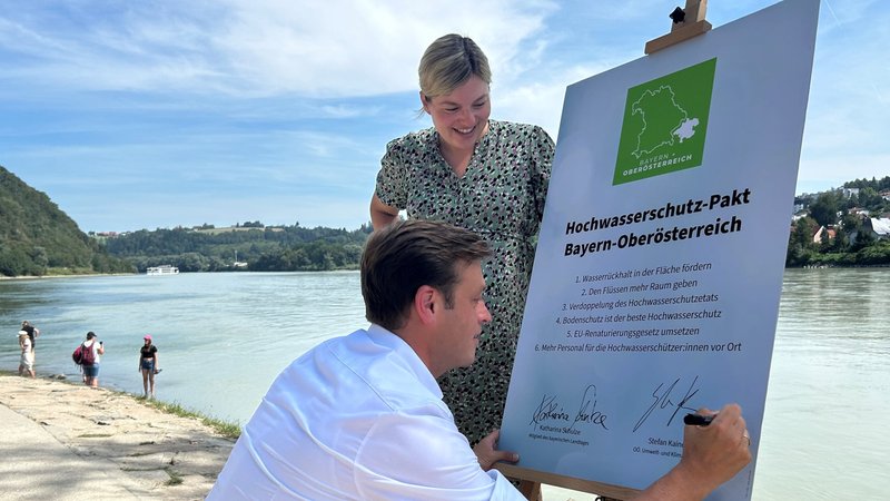 Katharina Schulze und Stefan Kaineder, Landessprecher der Grünen Oberösterreich, unterzeichnen den Pakt. | Bild: BR/Martin Gruber Katharina Schulze und Stefan Kaineder, Landessprecher der Grünen Oberösterreich, unterzeichnen den Pakt.