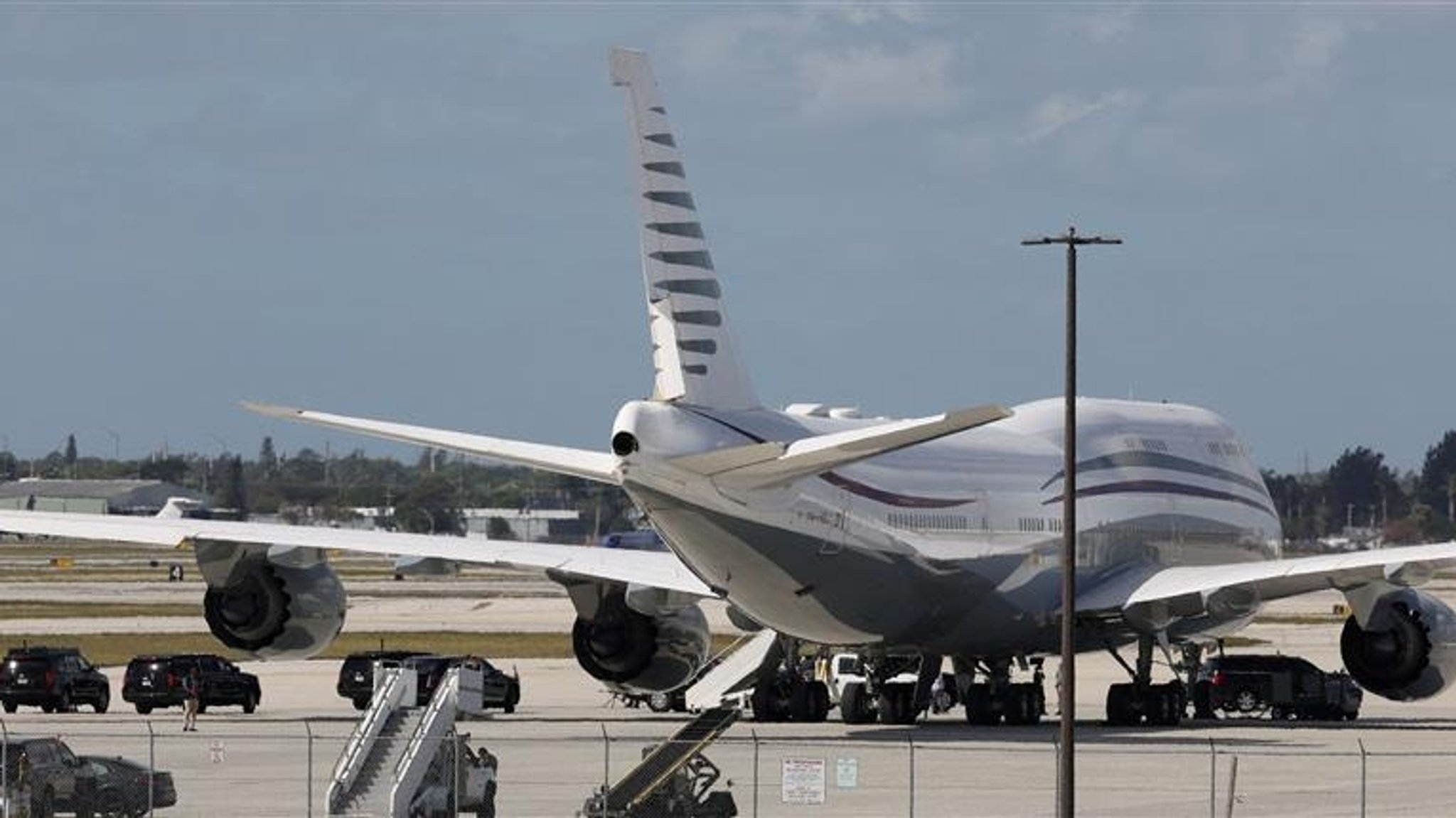 Der Fahrzeugkonvoi von US-Präsident Trump steht neben einer 12 Jahre alten Boeing 747-8 im Besitz Katars. 