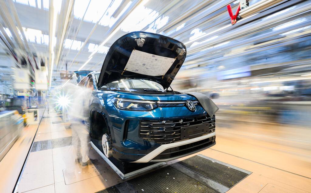 Ein Mitarbeiter arbeitet an einem Neuwagen der Marke Volkswagen.