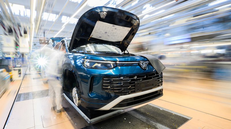 Ein Mitarbeiter arbeitet an einem Neuwagen der Marke Volkswagen. | Bild: dpa-Bildfunk/Julian Stratenschulte Ein Mitarbeiter arbeitet an einem Neuwagen der Marke Volkswagen.