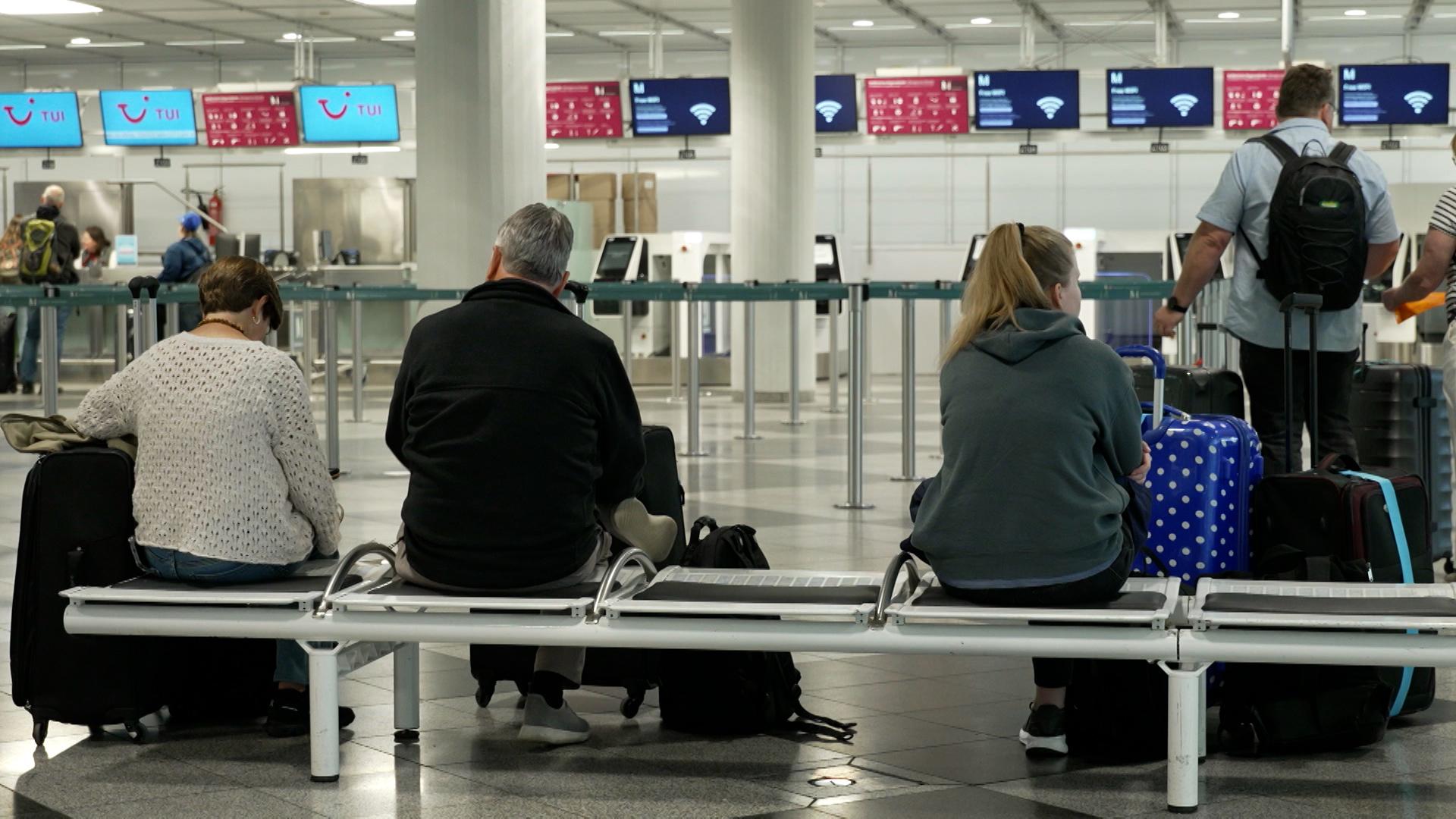 (Symbolbild) Passagiere warten im Check-in-Schalter im Flughafen