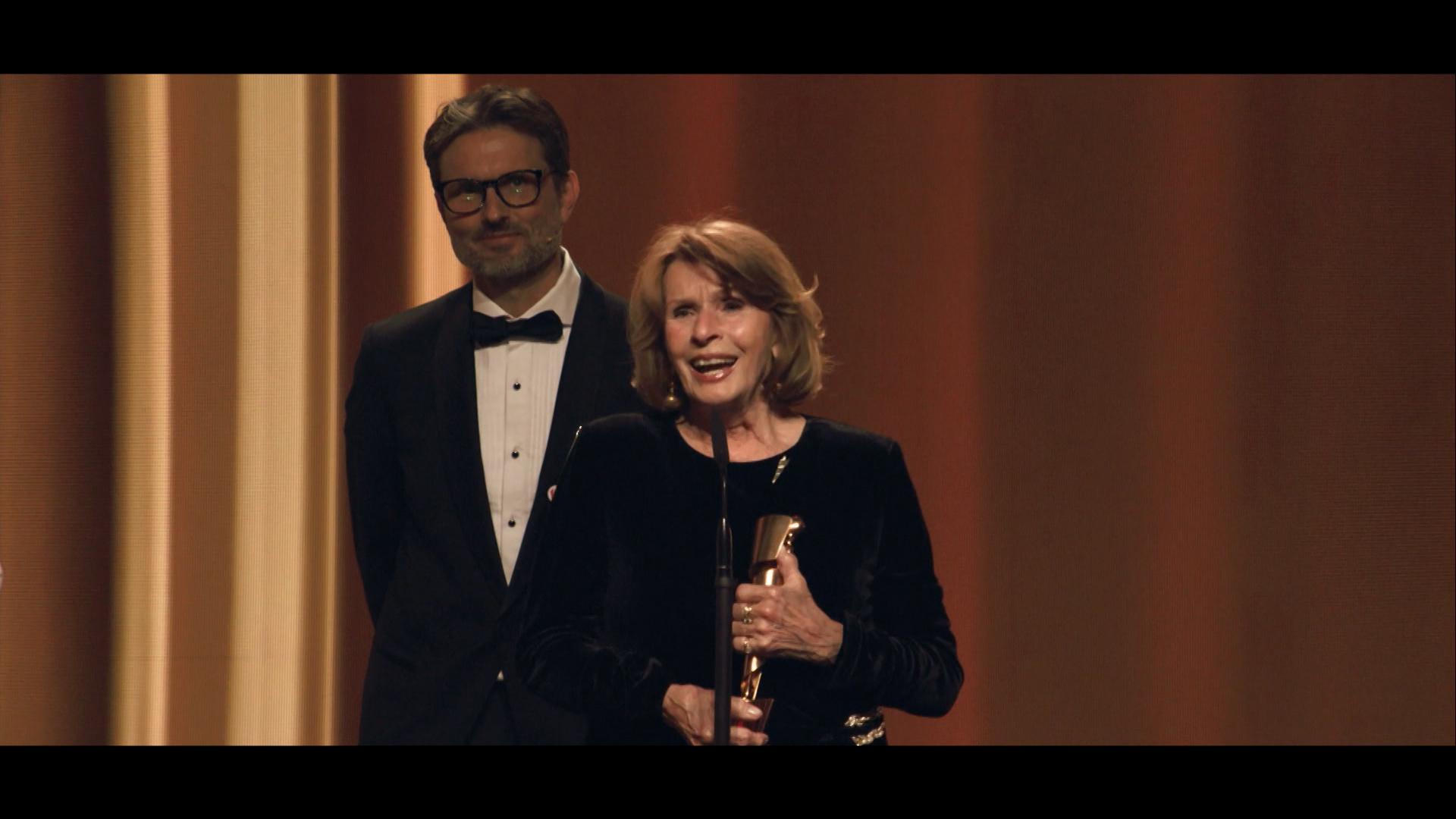 Senta Berger hält den Deutschen Filmpreis in ihren Händen; dahinter steht ihr Sohn, Regisseur Simon Verhoeven.