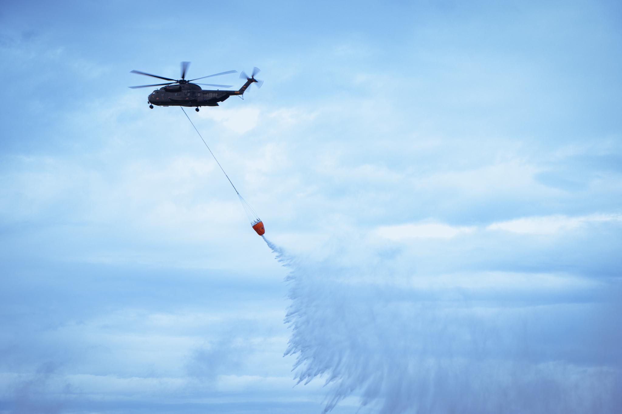 Ein CH-53 Hubschrauber transportiert bei der Großübung 7.000 Liter Wasser in einem Spezialbehälter.