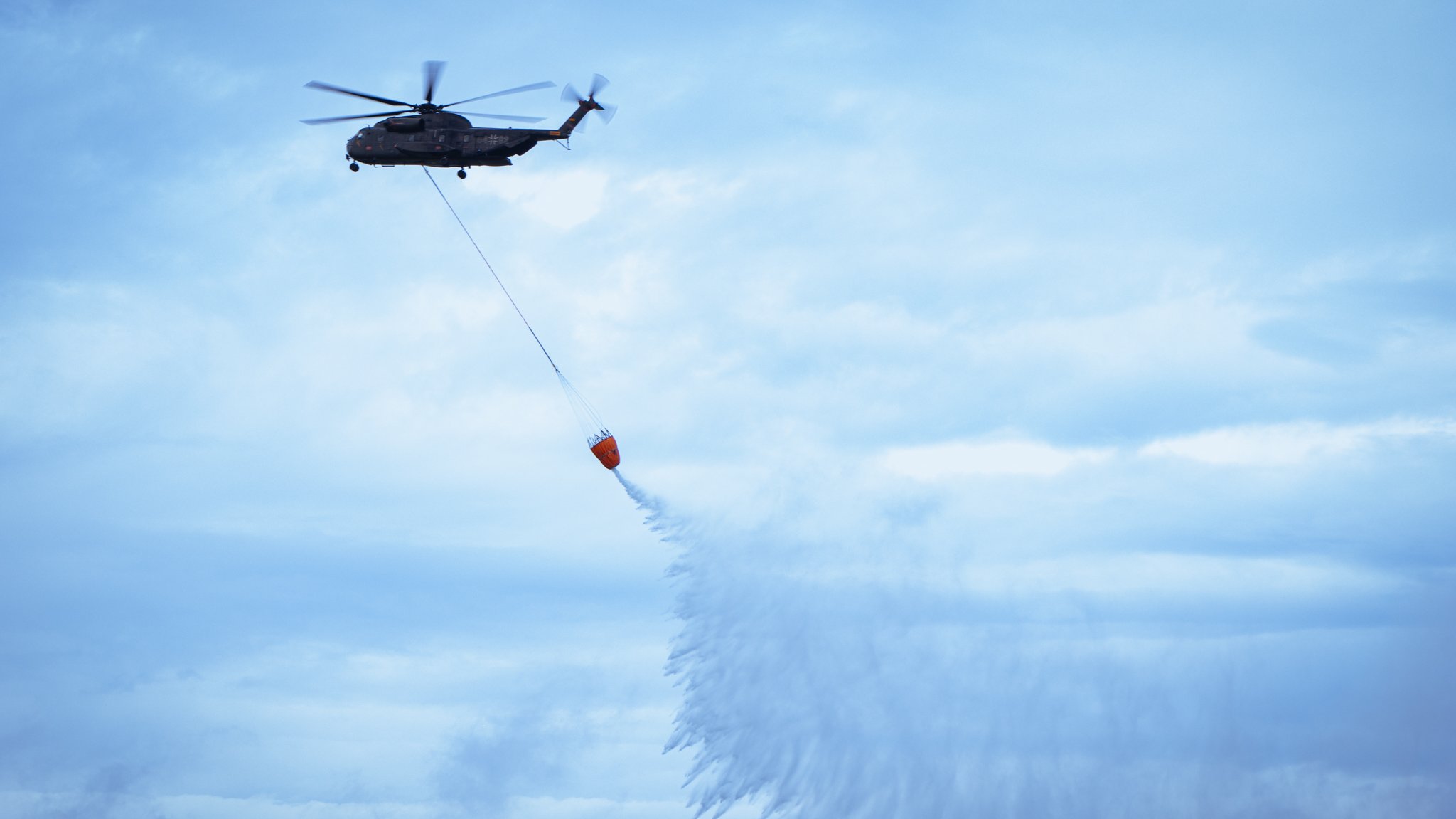 Ein CH-53 Hubschrauber transportiert bei der Großübung 7.000 Liter Wasser in einem Spezialbehälter.