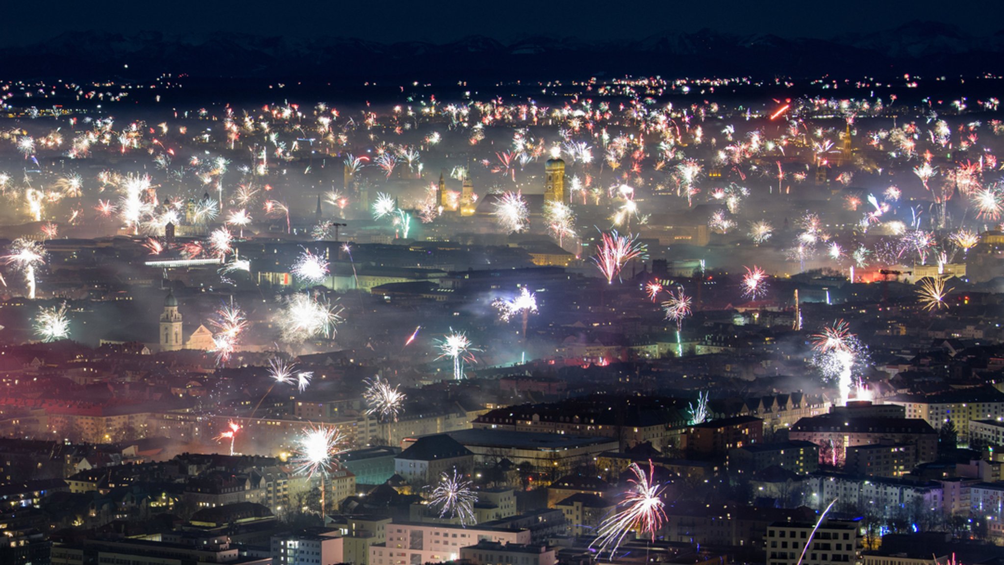 München: Feuerwerksraketen explodieren in der Silvesternacht 2018 über der Frauenkirche und der Innenstadt. 