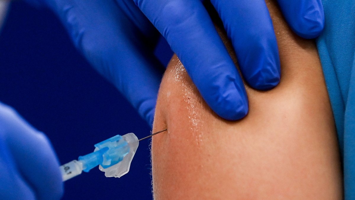 Das Bild zeigt eine Impfnadel, die in einen Oberarm gestochen wird.