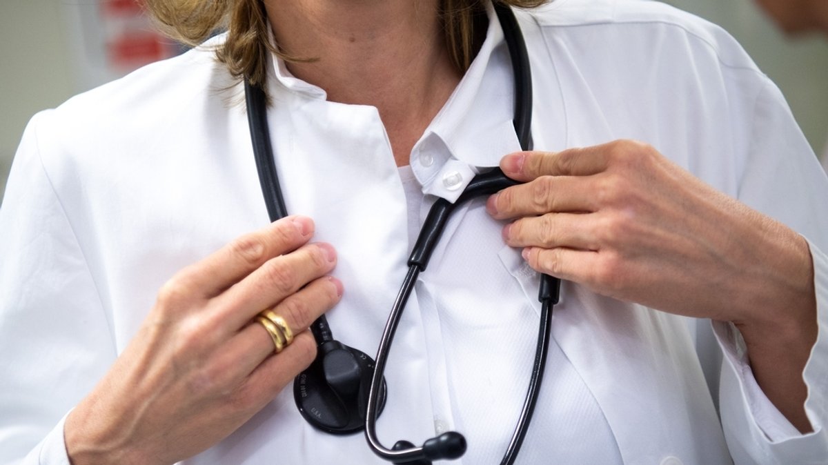 Eine Ärztin trägt in einem Krankenhaus ein Stethoskop um den Hals. 