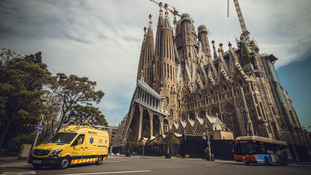 Barcelona: Ein Krankenwagen fährt an einer fast menschenleeren Straße an der "Sagrada Familia" von Gaudi vorbei.