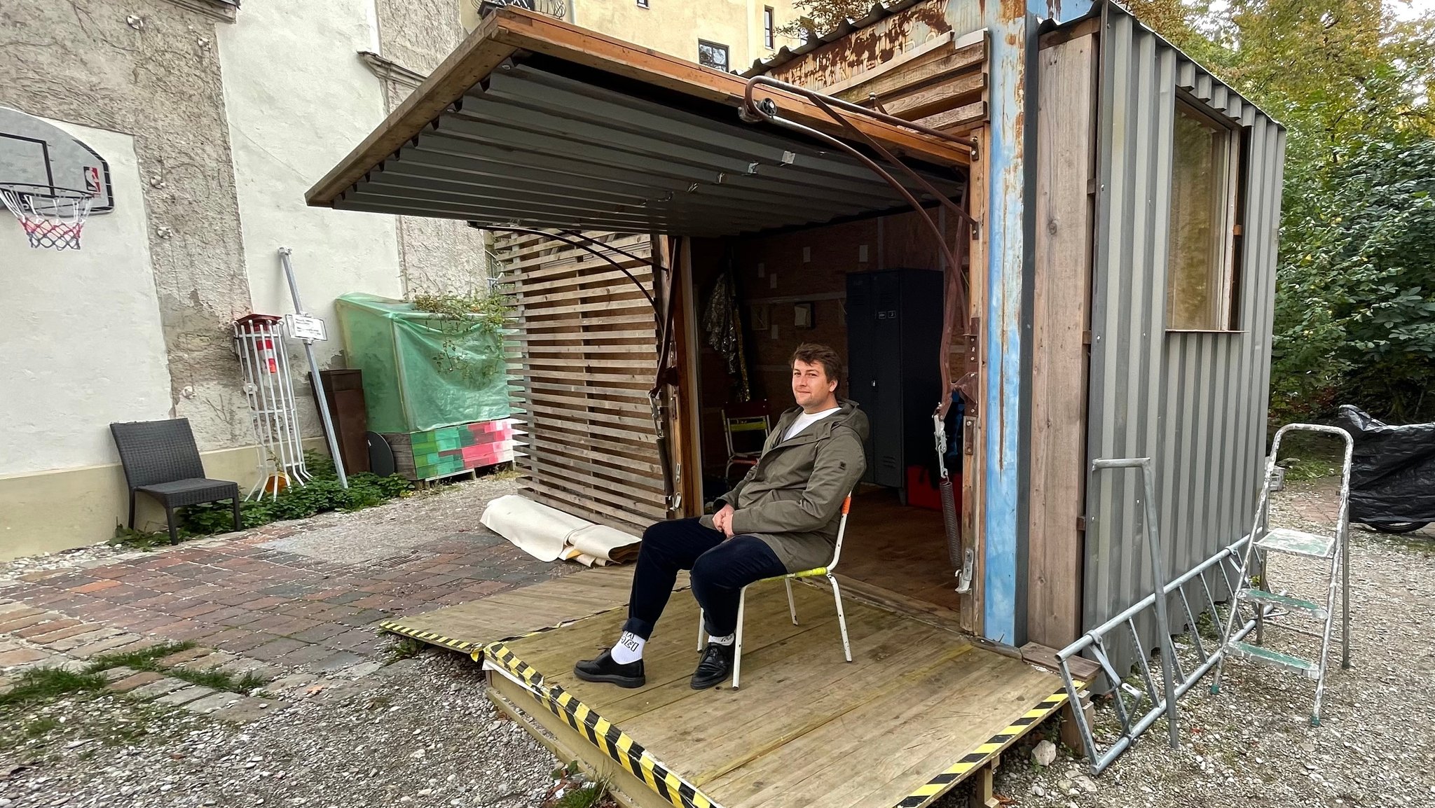 Johannes Daiberl sitzt vor seinem Secondhand-Container.