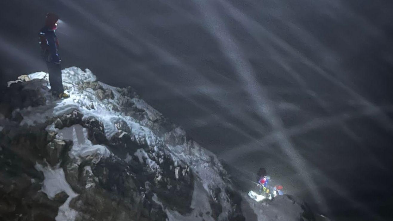 Drei Bergretter mit Stirnlampen bei der Rettungsaktion im Schneetreiben auf der Zugspitze.