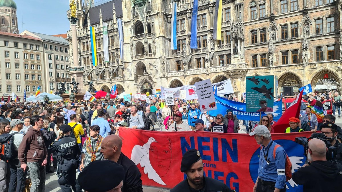 "Nein zum Krieg steht auf einem Banner. Mehrere hundert Teilnehmende haben sich auf dem Münchner Marienplatz vor dem Rathaus versammelt. 