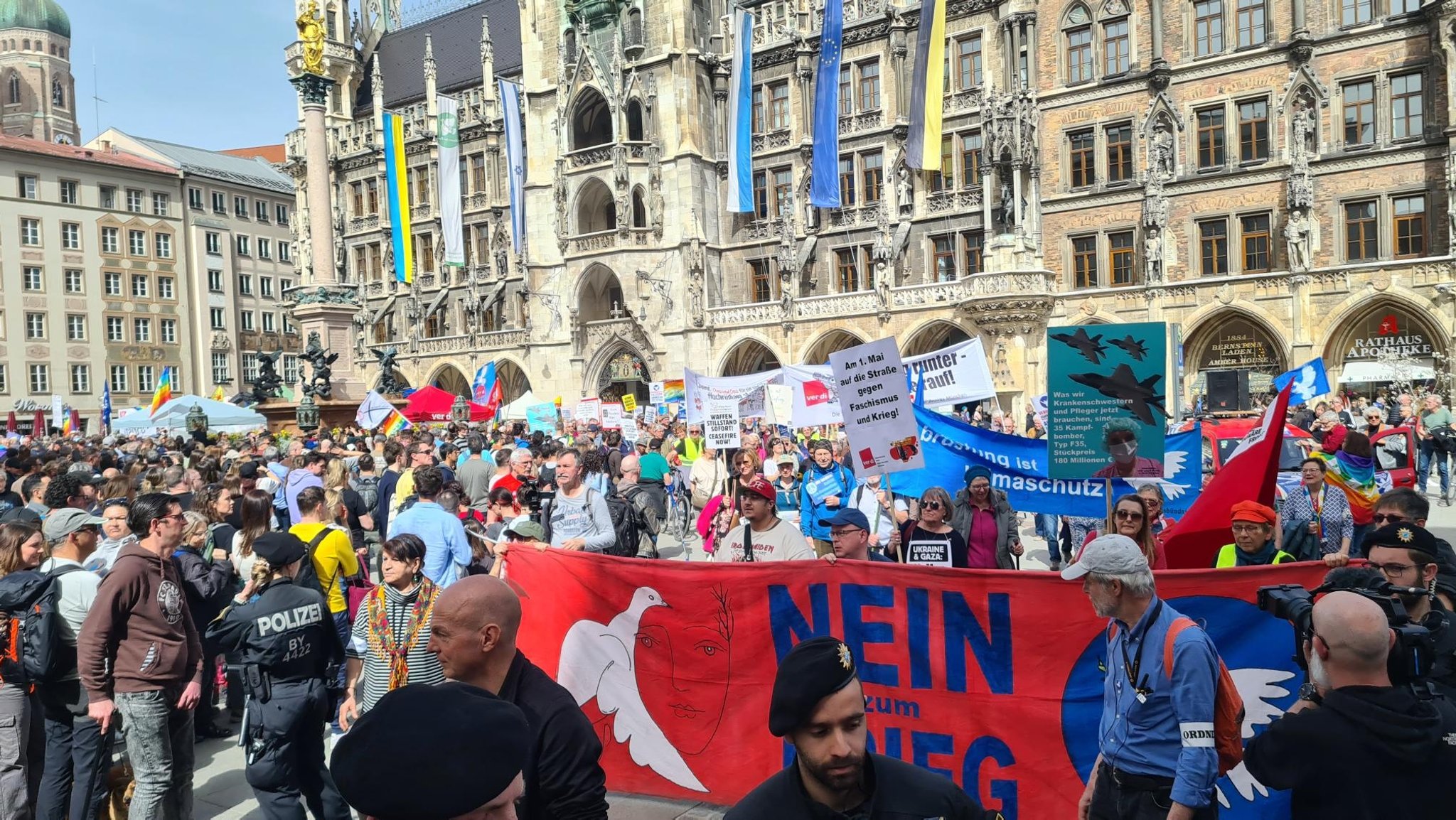 "Nein zum Krieg steht auf einem Banner. Mehrere hundert Teilnehmende haben sich auf dem Münchner Marienplatz vor dem Rathaus versammelt. 