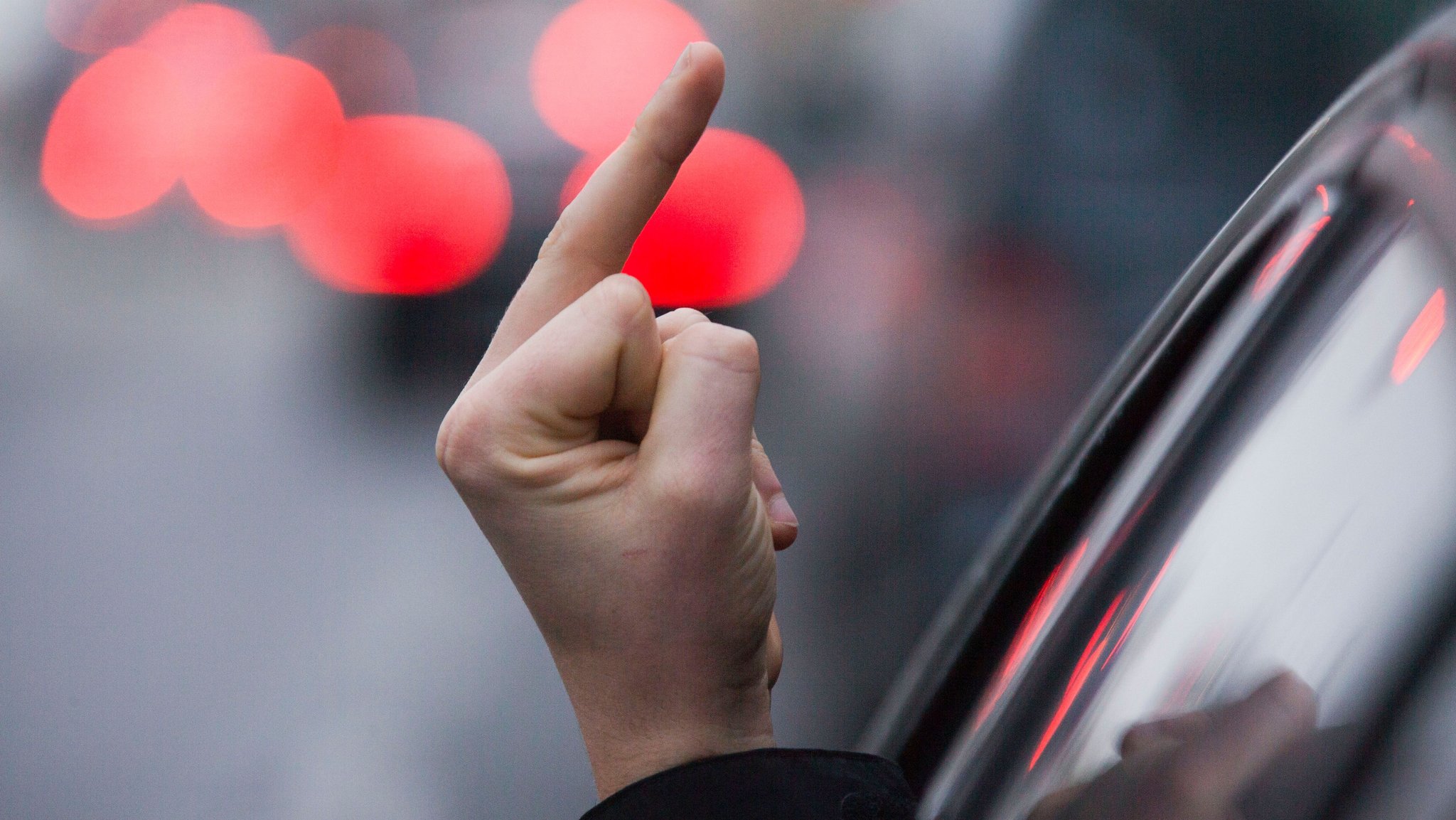 Symbolbild: Einen sogenannten Stinkefinger zeigt ein Autofahrer aus seinem Auto.