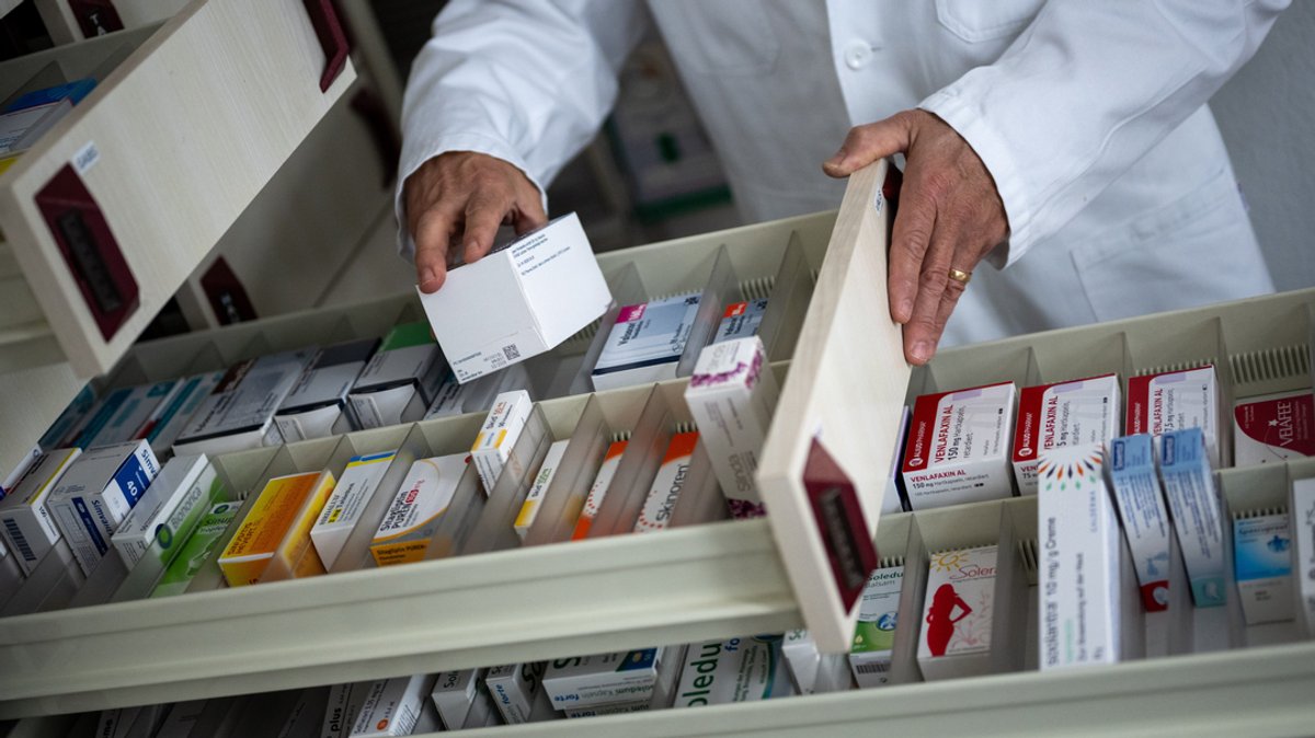 Ein Apotheker holt eine Medikamentenverpackung aus einer Schublade (Symbolbild) 