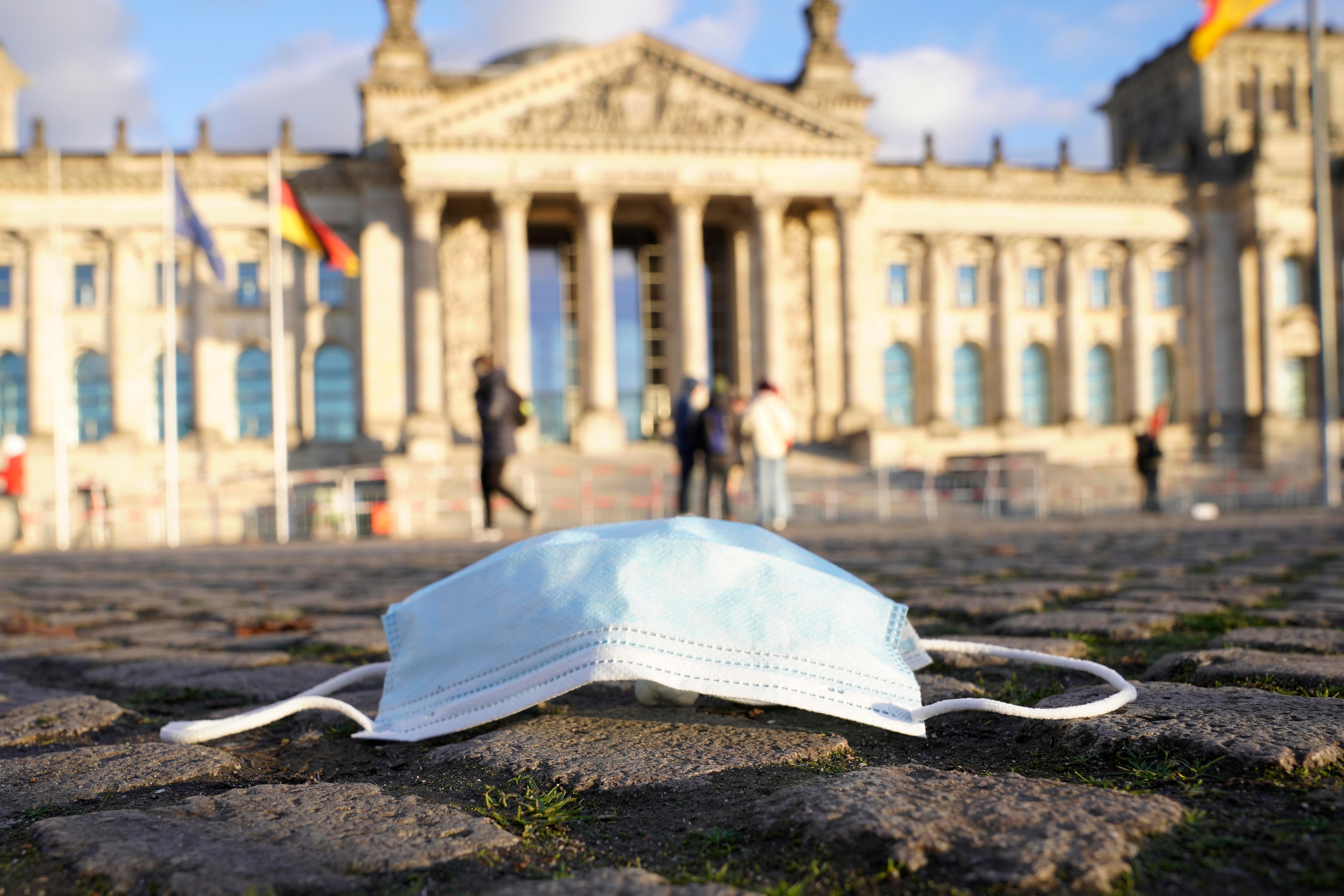 Vor dem Bundestag liegt eine Corona-Maske. (Archivbild)