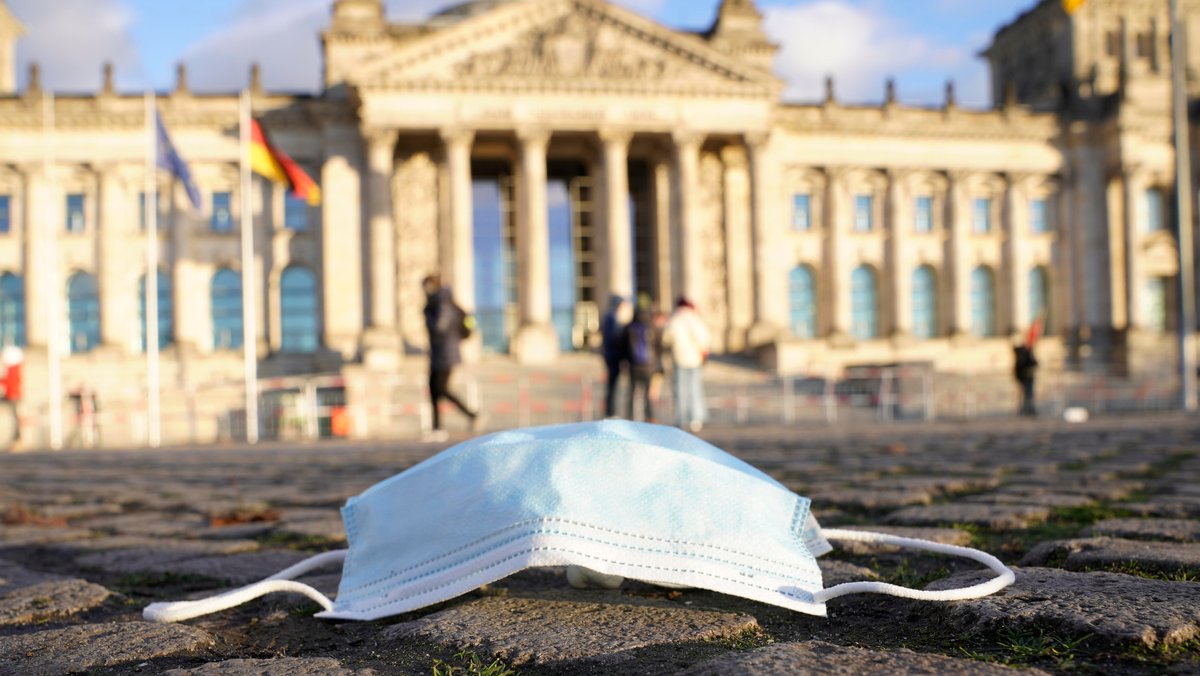 Vor dem Bundestag liegt eine Corona-Maske. (Archivbild)