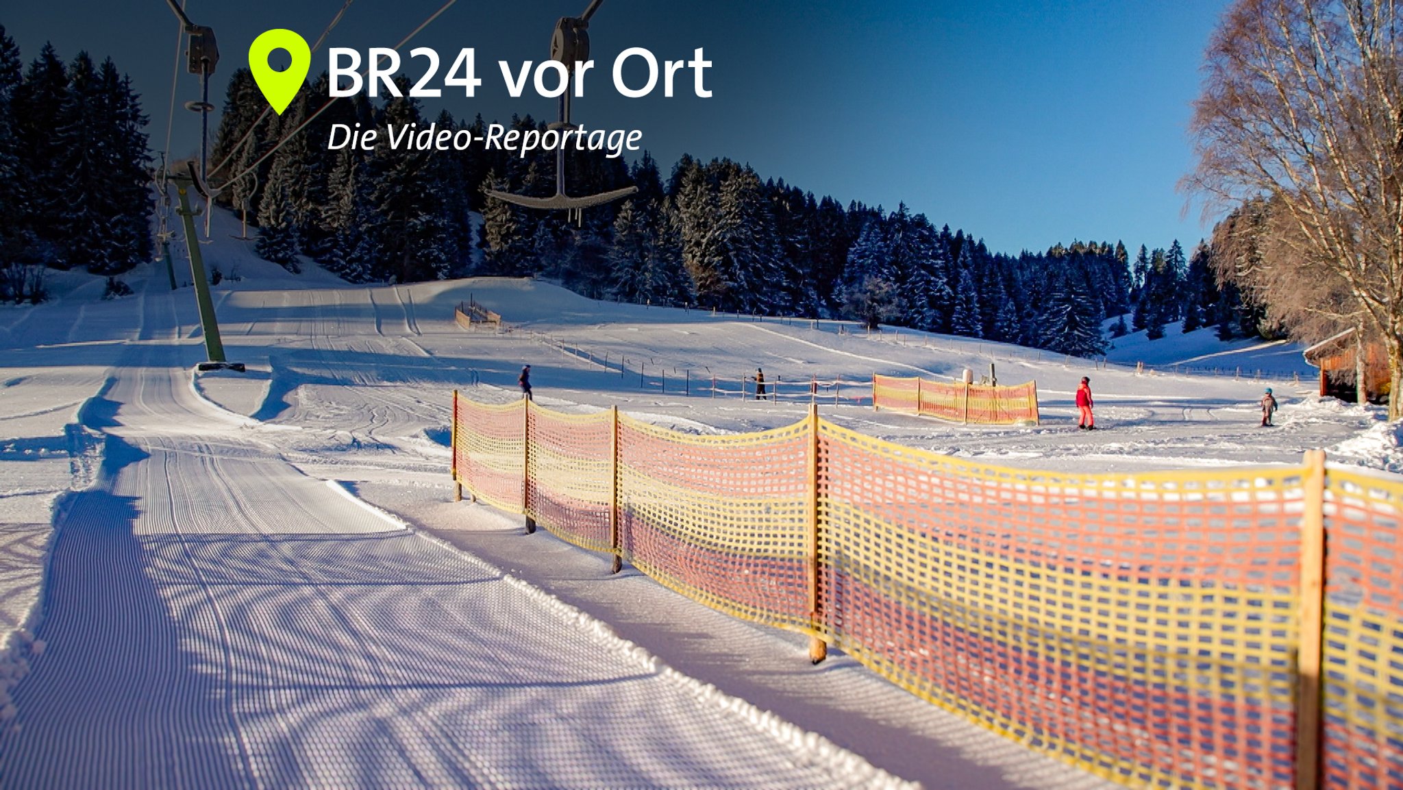 Eine sonnige Piste, die schneebedeckten Nadelbäume werfen lange Schatten, am Schlepplift hängen Eiszapfen.