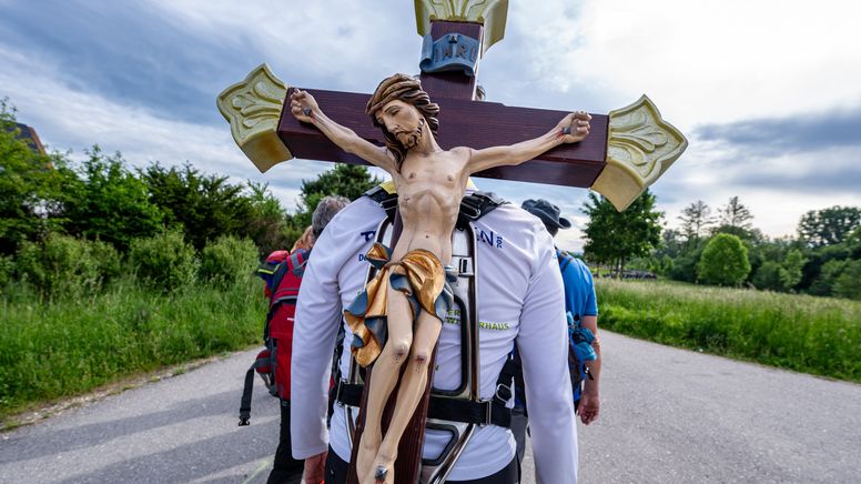 Ein Pilger trägt während der größten Fußwallfahrt Deutschlands ein Holzkreuz auf dem Rücken. | Bild:dpa-Bildfunk/Armin Weigel