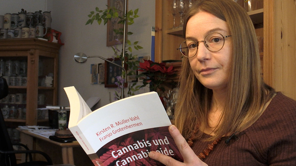 Frau liest ein Buch über Cannabis in der Medizin.