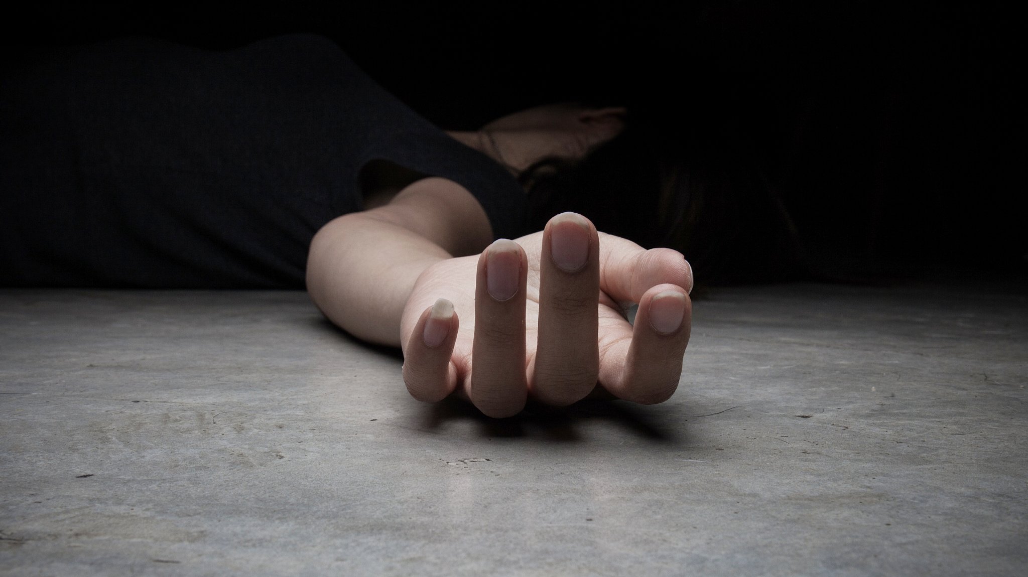 Hand einer am Boden liegenden Frau - Symbolbild 