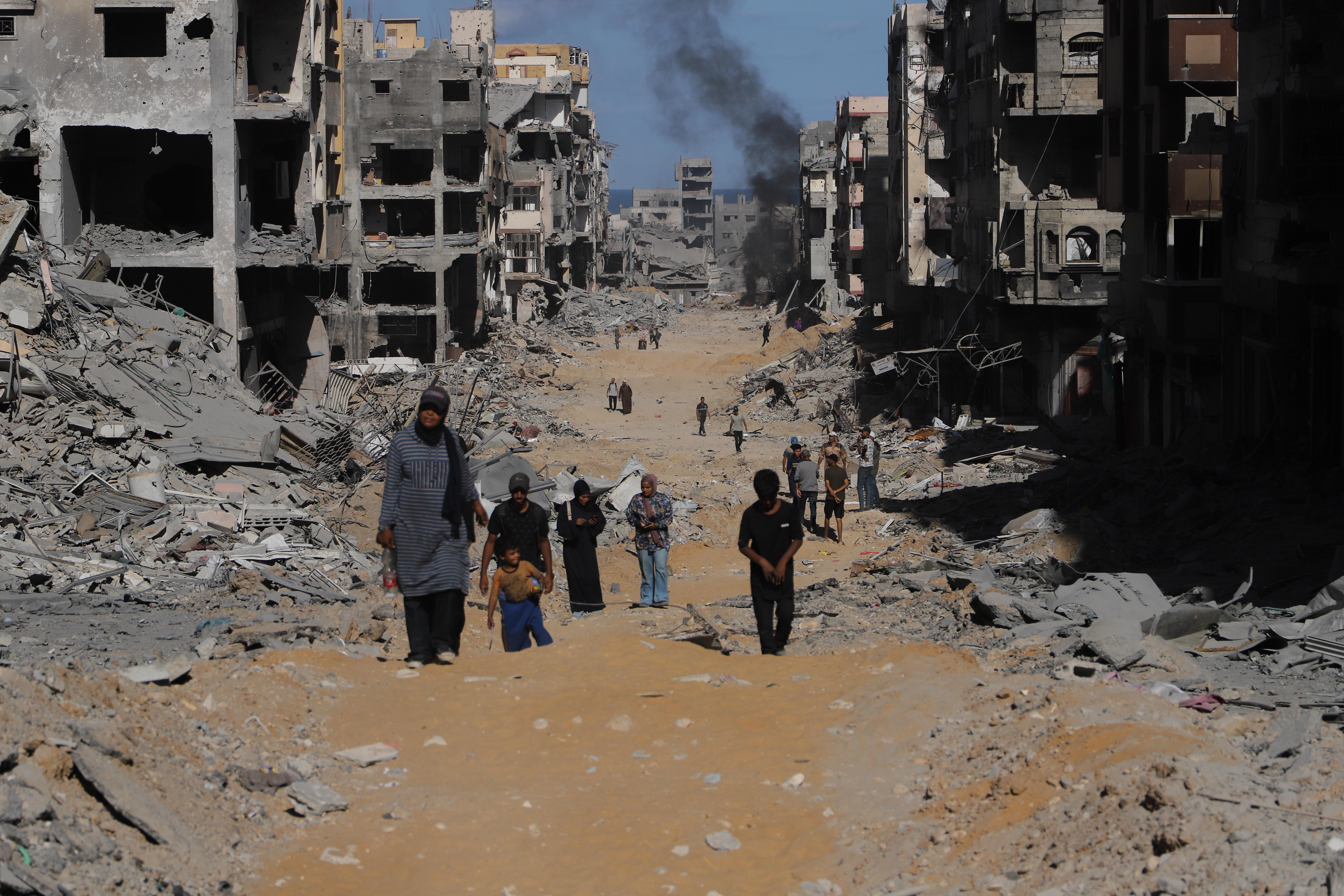 Mehrere Palästinenser sichten die Schäden in einem von der israelischen Armee zerstörten Ort im Gazastreifen.